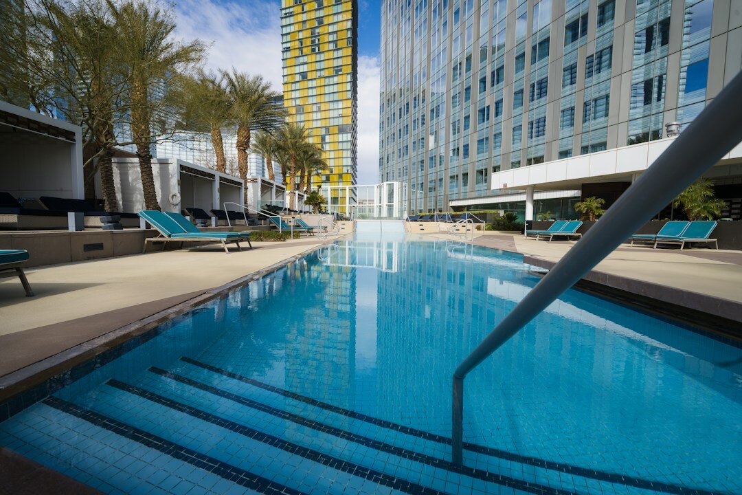 an empty swimming pool with lounge chairs around it