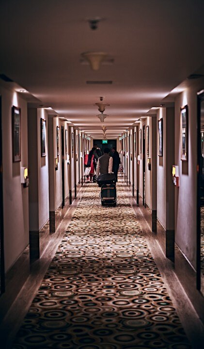 person in black jacket walking on hallway