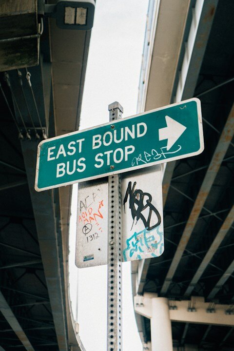 a green street sign sitting under a bridge